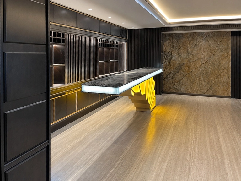 Private lounge area in Nice featuring bespoke bar counter in Black Marquinia marble and back-lit glass by Chiodelli Arte
